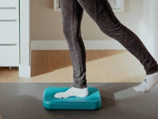 Exercice de proprioception et de contrôle du pied sur plateau instable, travail clé dans la rééducation du syndrome de l'essuie-glace
