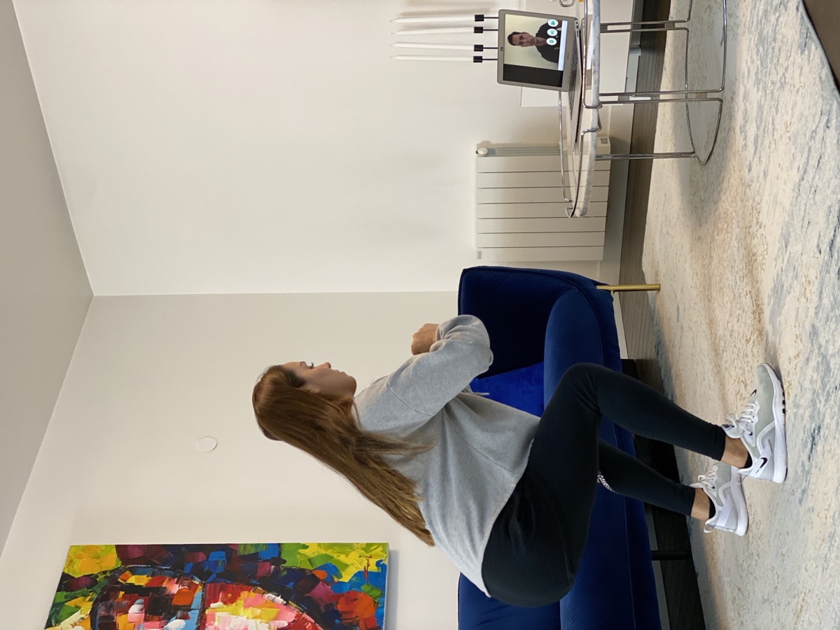 Patiente réalisant un exercice de squat guidé en visioconférence