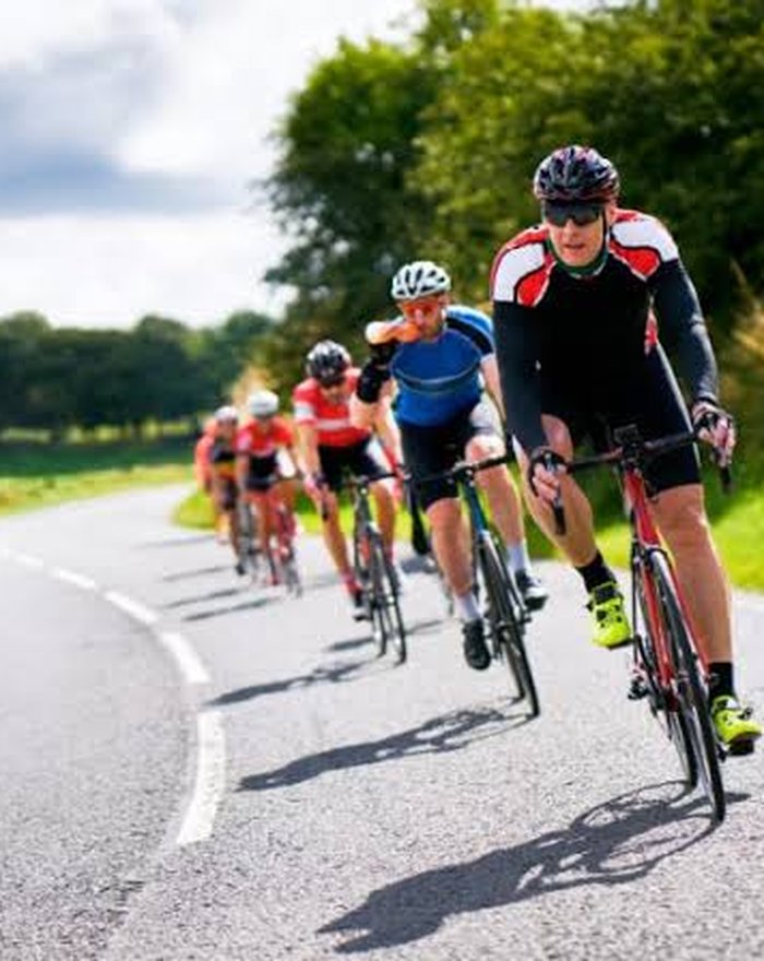 Cycliste réglant sa position sur son vélo