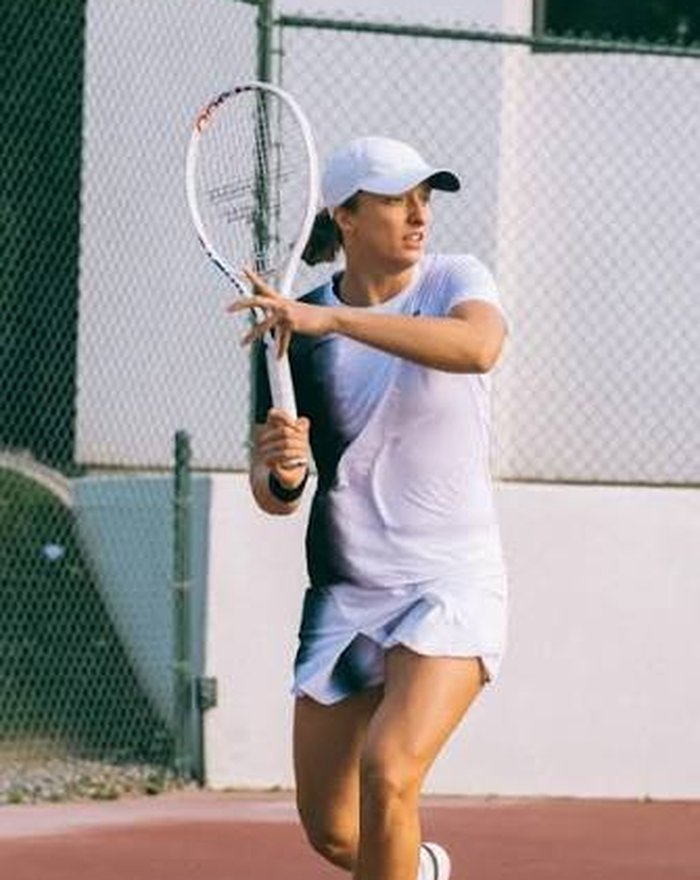 Jugador de tenis sacando en una pista